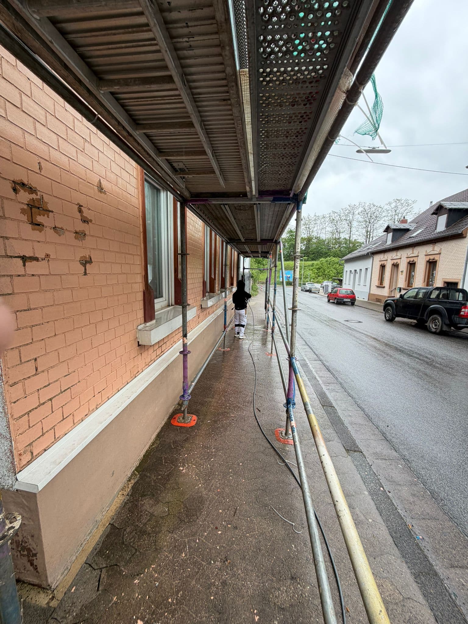 Detailaufnahme einer frisch gestrichenen Putzfassade mit sauberem Anschluss am Fenster.